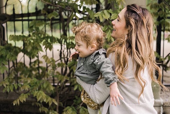baby photographer columbus ohio mom spins baby girl near wall of wisteria