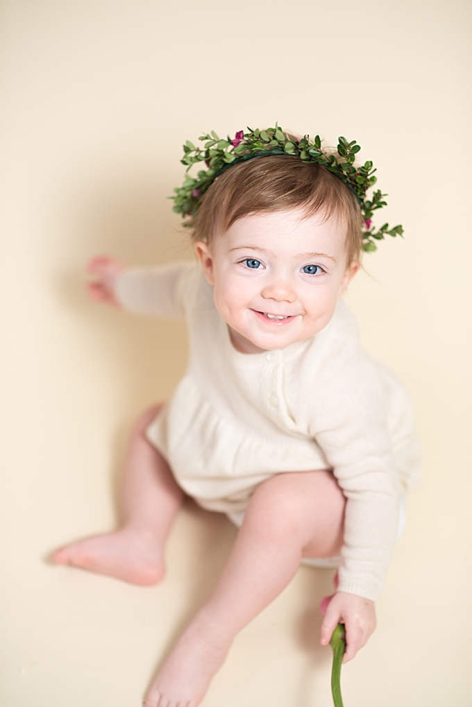 baby photographers columbus ohio baby dressed in creams smiles while wearing flower crown