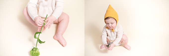 columbus baby photographer baby squats and plays with flowers in yellow hat