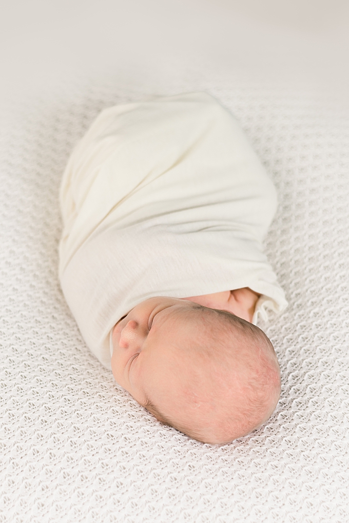 newborn baby wrapped in white swaddle