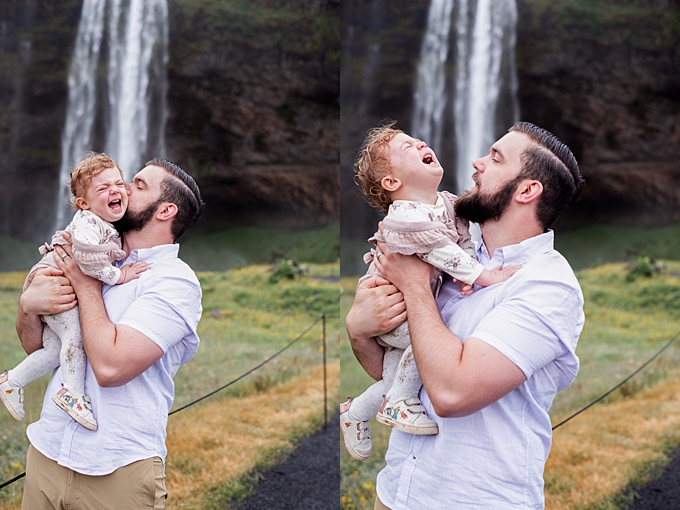 baby crying in dads arms in front of waterfall