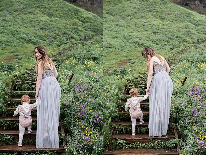 columbus ohio family photographer walks with her daughter up the stairs to seljalandsfoss in iceland dressed in bhldn