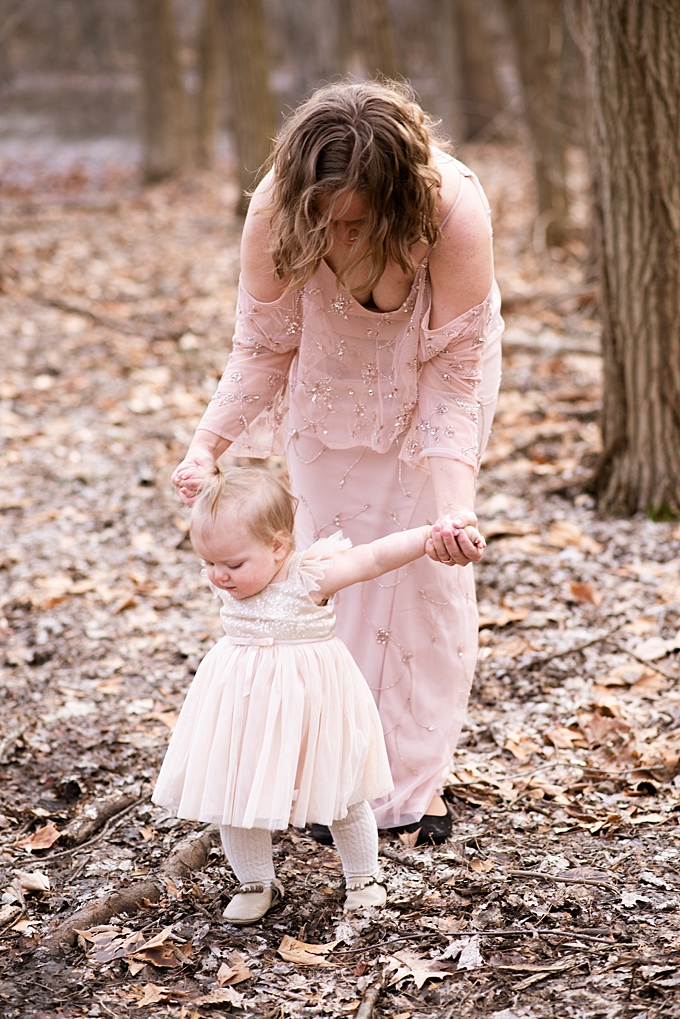 columbus family photographer mom dressed in pink beaded adrianna papell walks with toddler dressed in blush sequin popatu dress