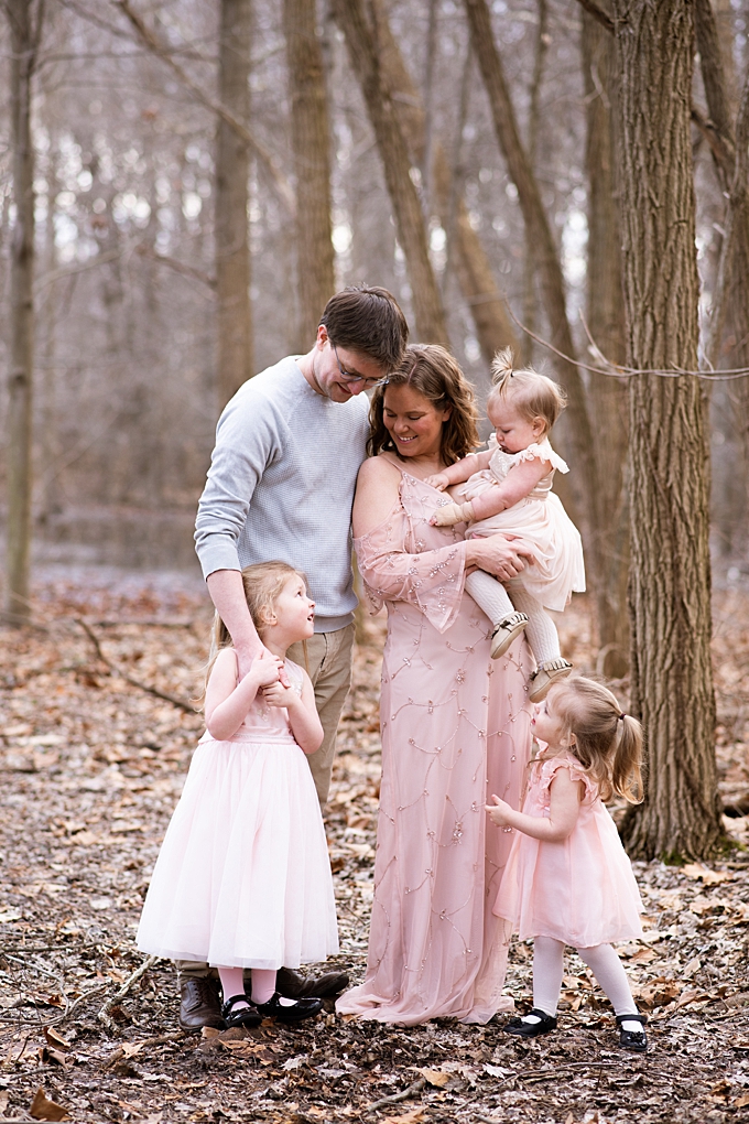 columbus family photographer family of five cuddle outside in the forest 