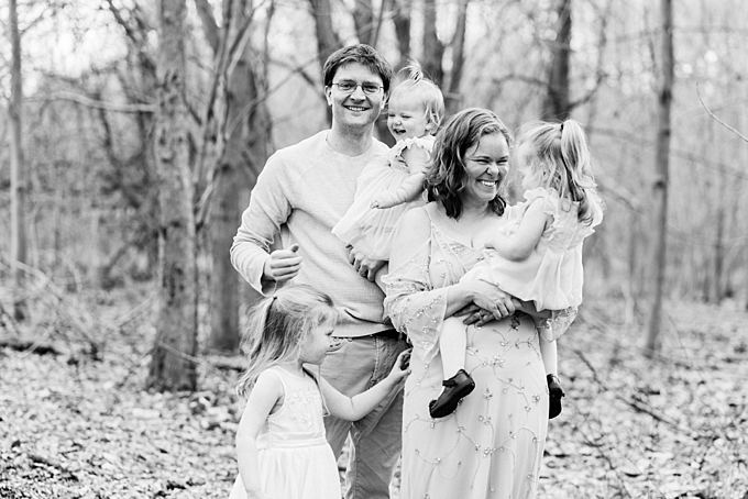columbus family photographer black and white image of family snuggling in the forest