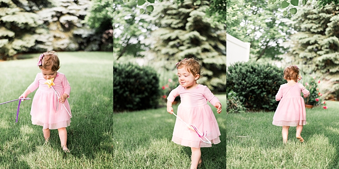 baby photography columbus ohio toddler plays and runs with wand in backyard