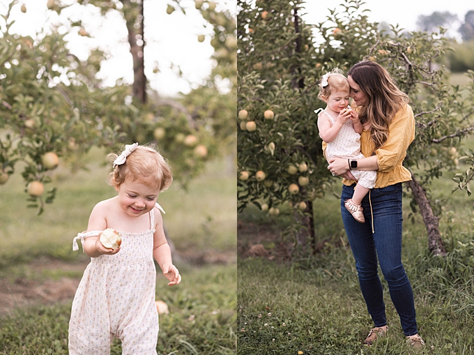 columbus baby photography mom cuddles daughter while she eats apple in orchard
