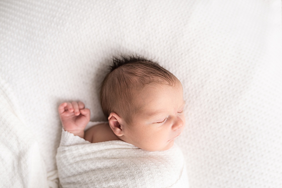 newborn boy sleeps with one hand unwrapped