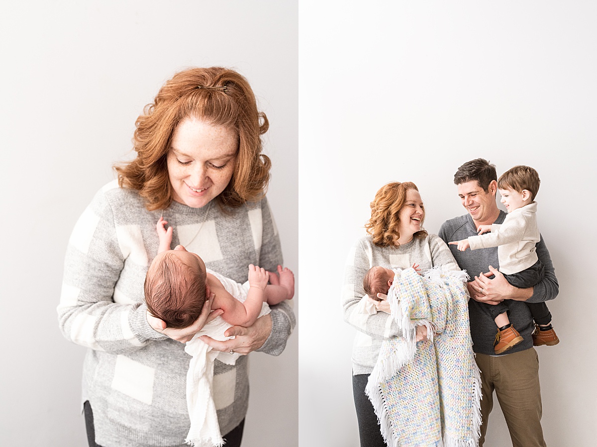 photography newborn mom holds newborn baby boy and toddler points to him