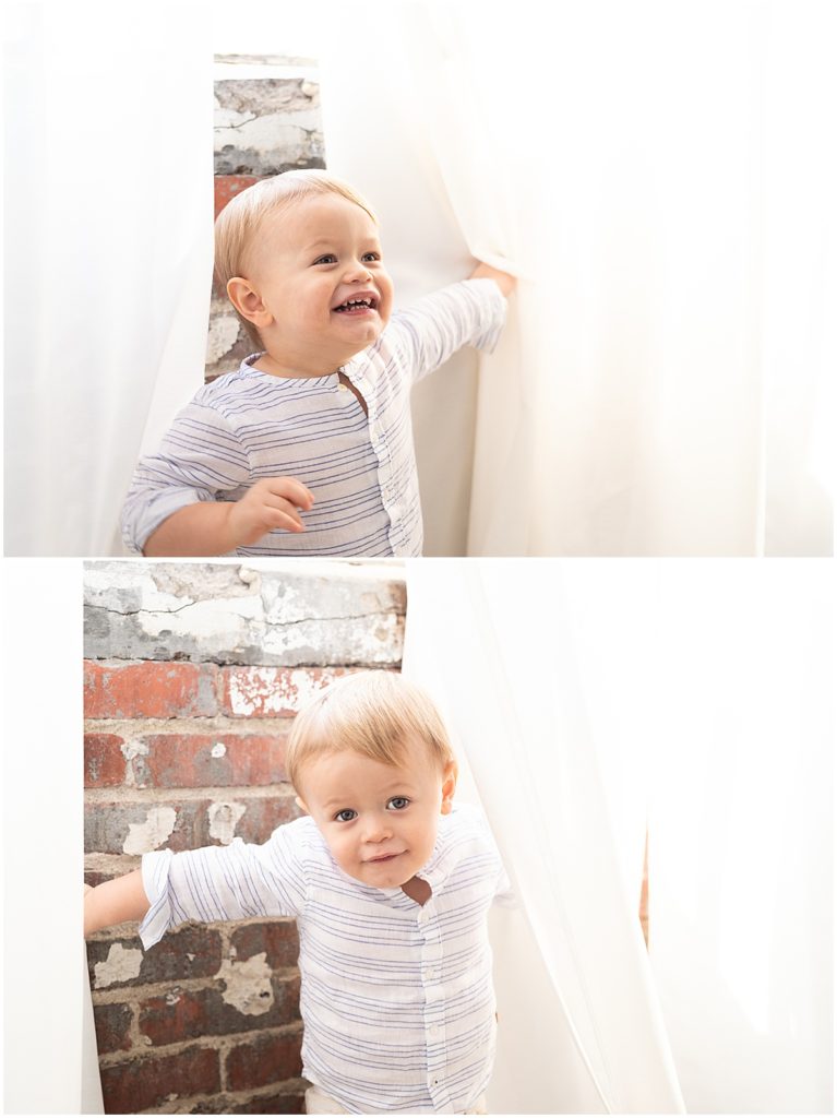 toddler boy peeks out and plays in curtains