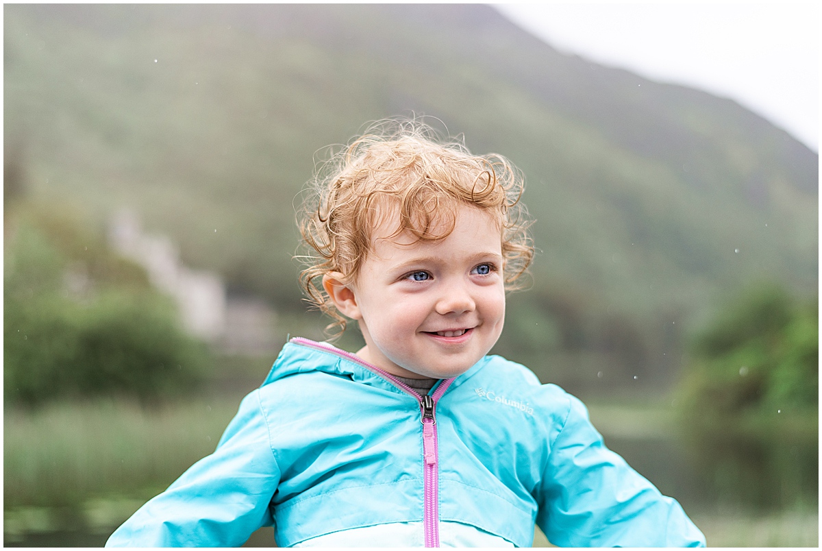 europe travel photographer portrait of toddler with curly hair in the rain 