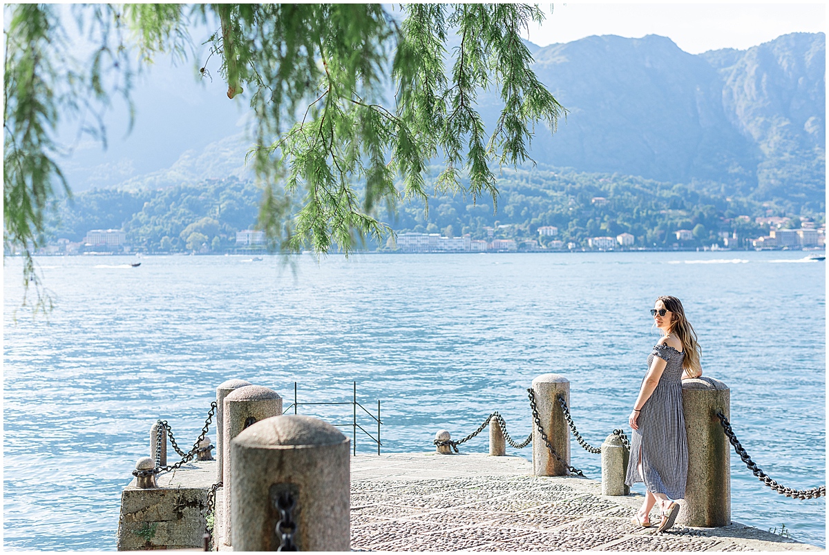 lifestyle travel photographer woman in black dress looks out at lake como