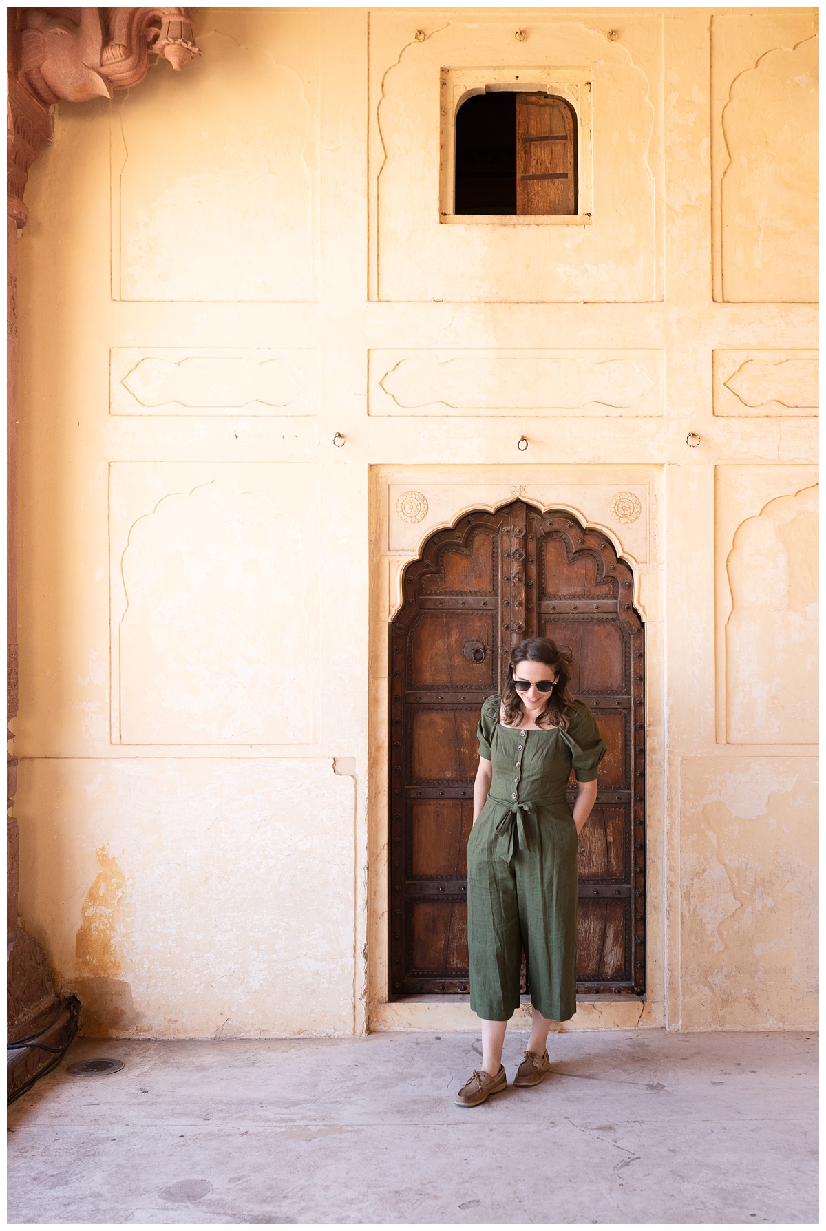 ohio lifestyle photographer stands in amer fort yellow walls