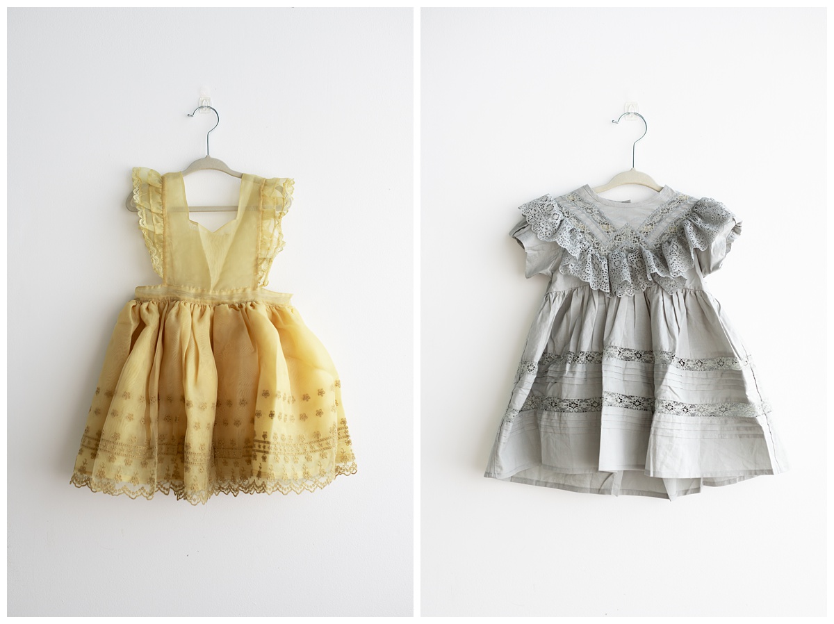 Yellow noralee tulle dress and grey lacy dress on white wall