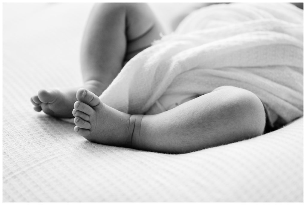 details of newborn girls legs and feet in black and white