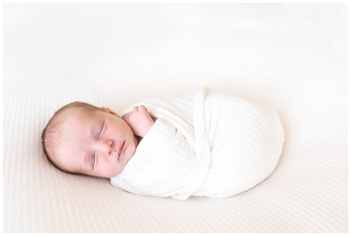 newborn girl sleeps in white wrap