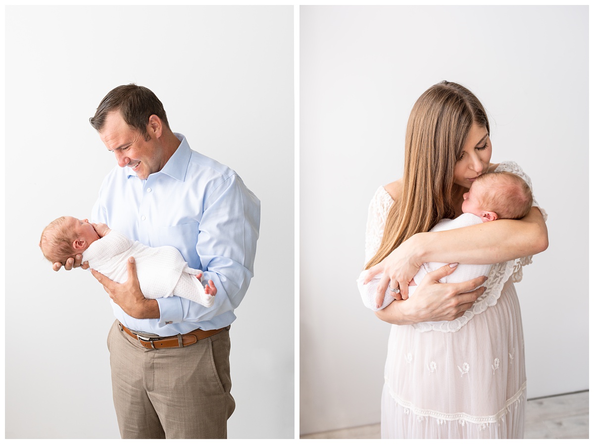 mom and dad snuggle baby boy in blue studio newborn session columbus