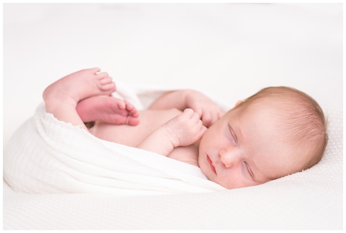 Top Newborn Photographer Columbus Ohio newborn unposed sleeps on wrapped in white 
