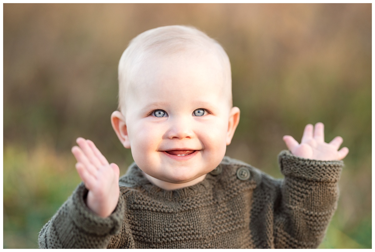 Top baby Photographer Columbus Ohio baby claps hands and smiles outside