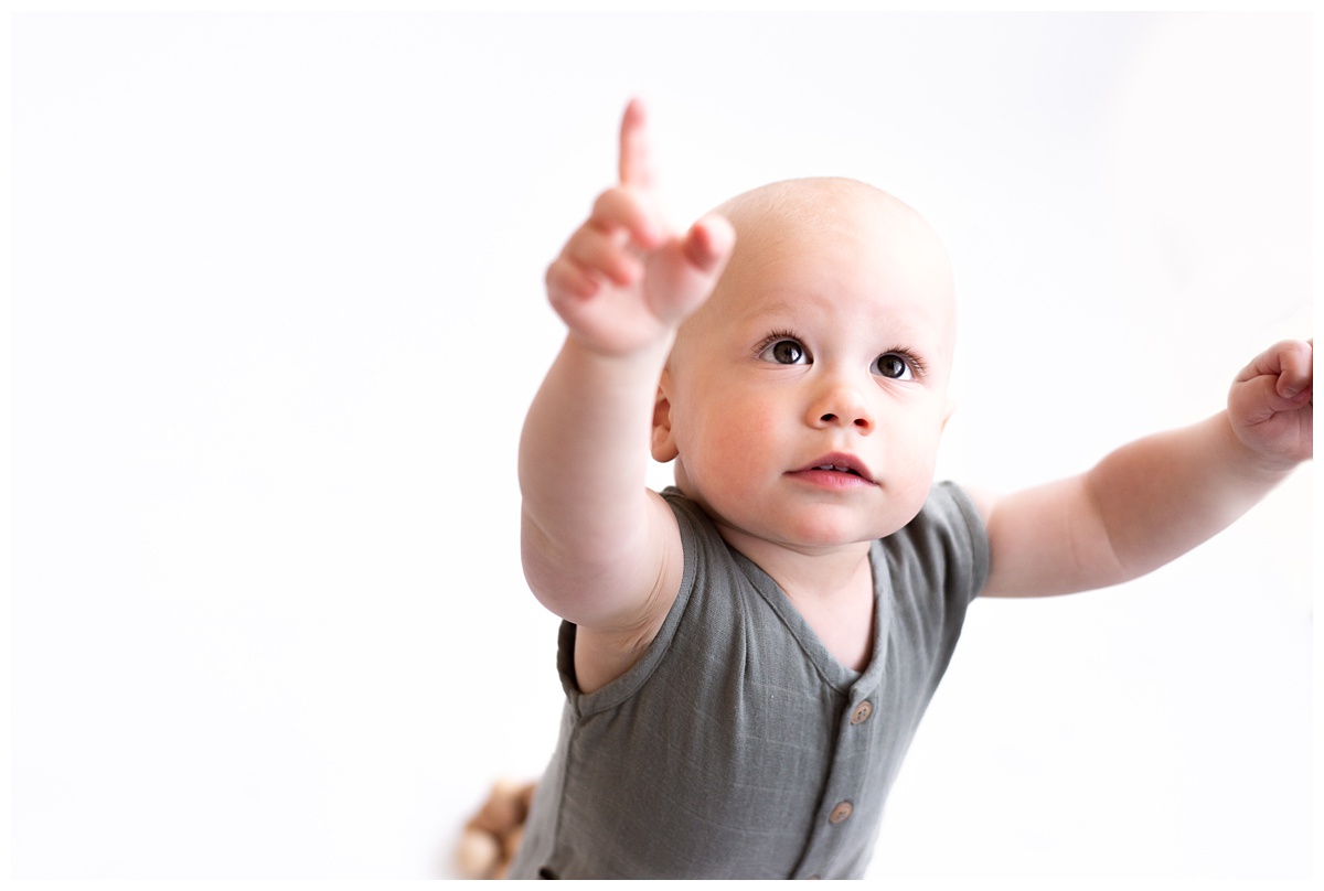 Top baby Photographer Columbus Ohio toddler reaches high in studio