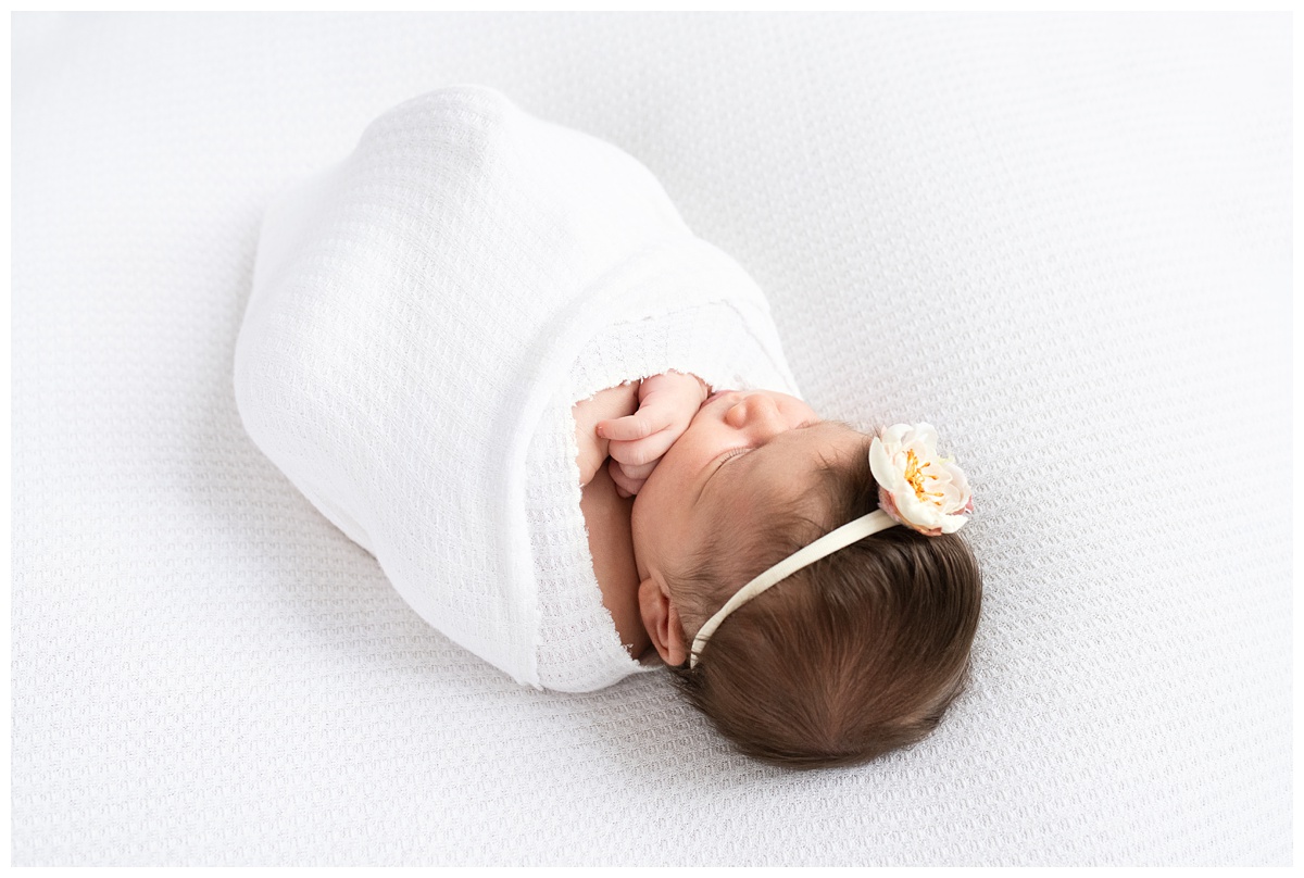 Top Newborn Photographer Columbus Ohio newborn girl wrapped in simple white with flower headband