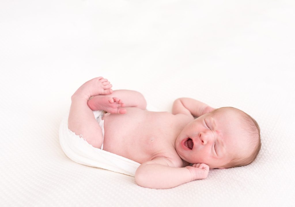 columbus ohio newborn photographer newborn yawns and stretches in invory