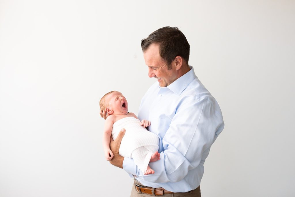 columbus ohio newborn photographer newborn yawns in dads arms