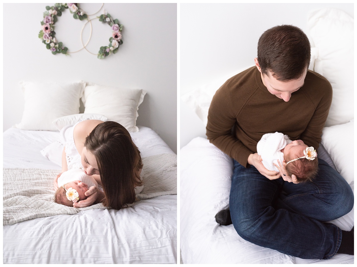 Lifestyle Newborn Photographer Columbus Ohio mom and dad hold baby girl on white bed