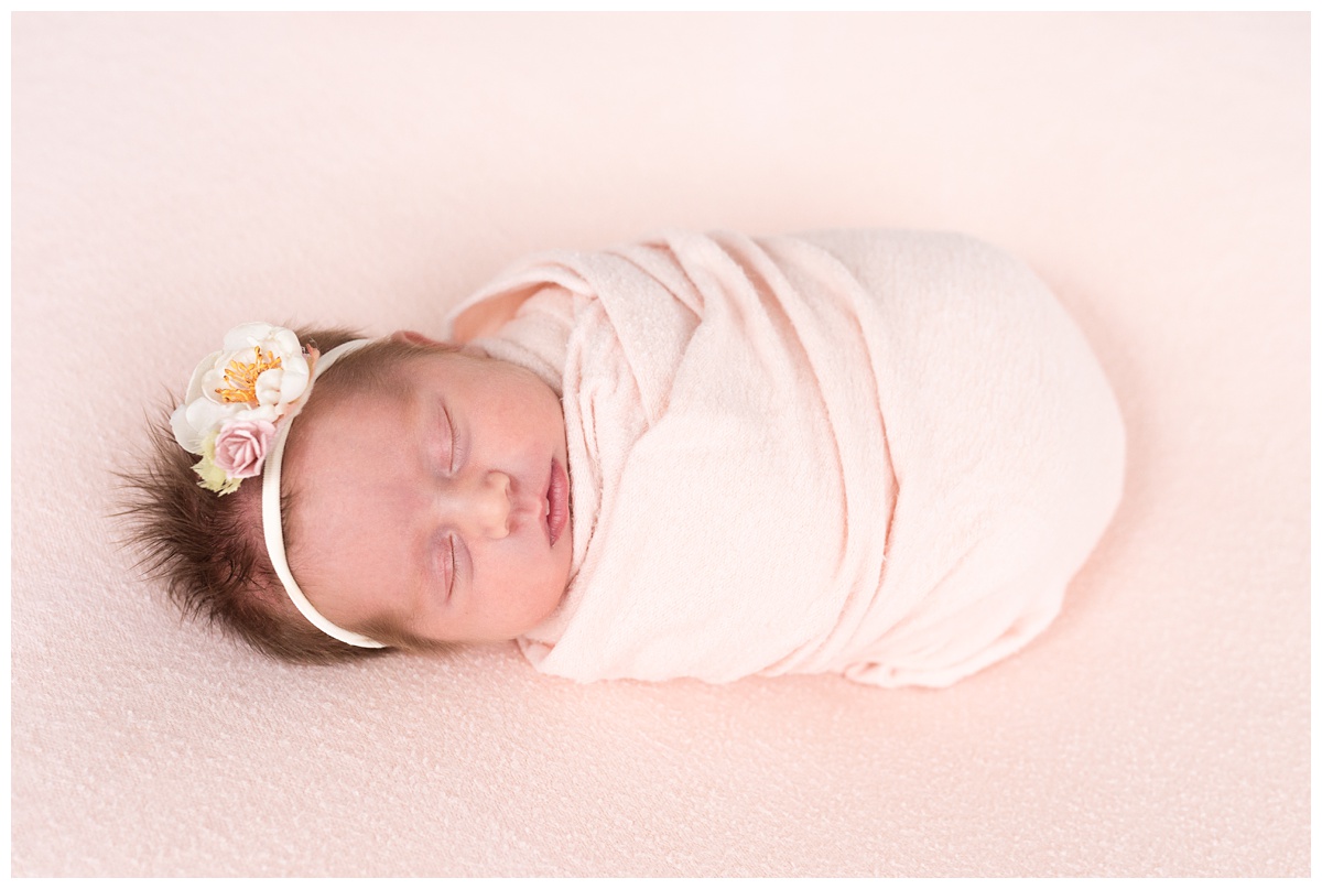 Lifestyle Newborn Photographer Columbus Ohio baby girl wrapped in pink with floral headband