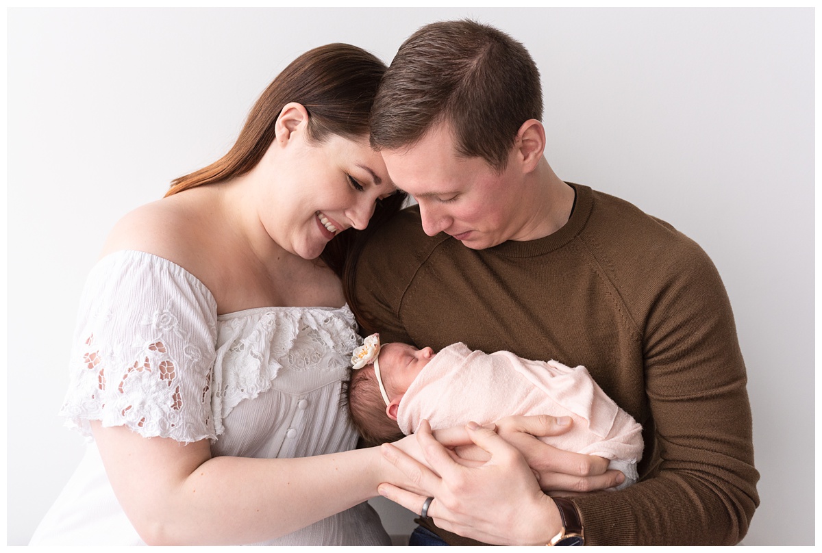 Lifestyle Newborn Photographer Columbus Ohio mom and dad smile down at baby girl