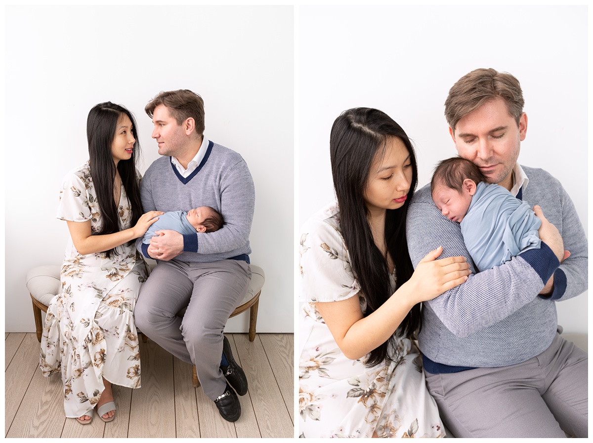 Best Columbus Newborn Photographer mom and dad sit on bench in studio holding newborn boy in blue