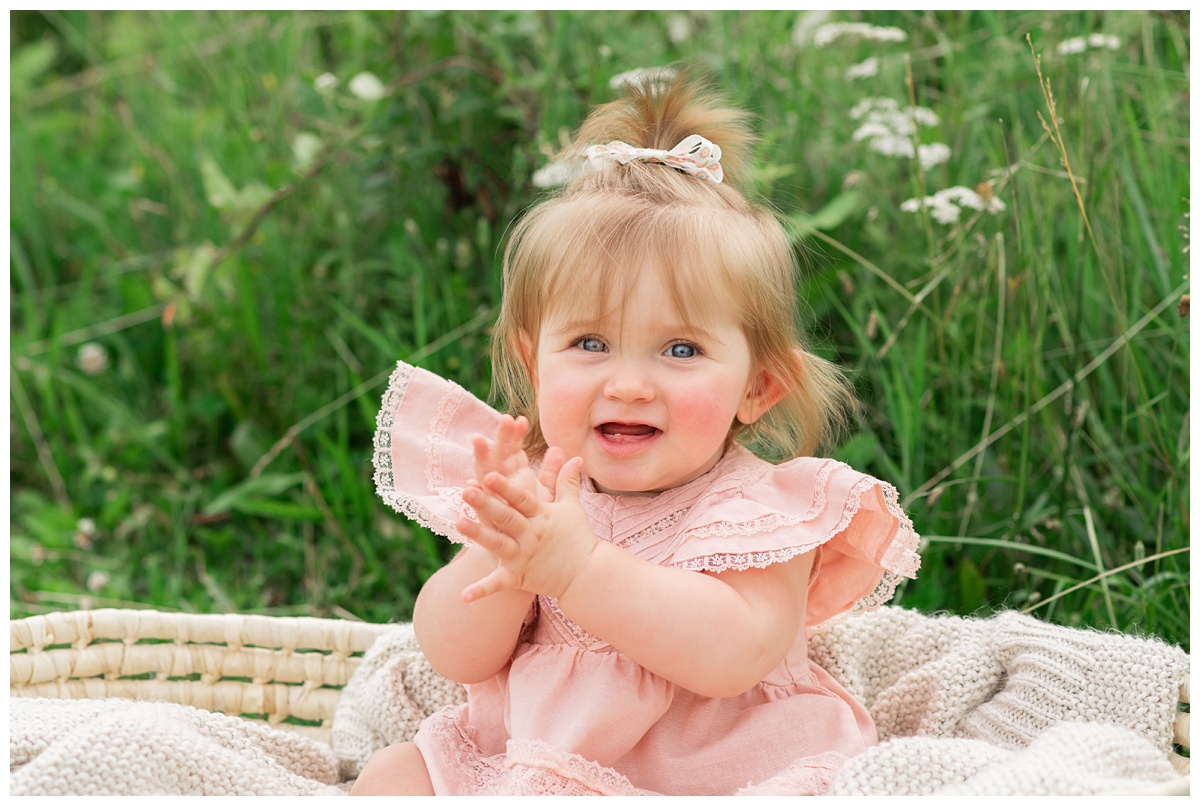 baby girl in pink dress clapping