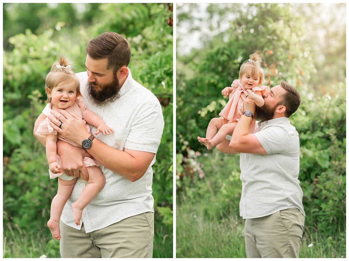 Family Photographers Columbuss dad in white shirt and khakis holds baby girl in pink dress and smiles