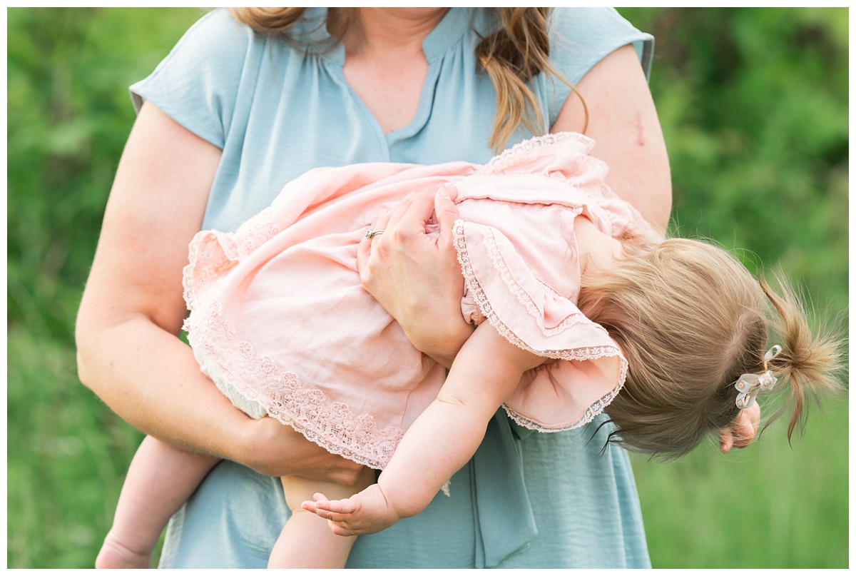 Family Photographers Columbus Ohio Summer 2021 mom holds toddler outside in blue dress