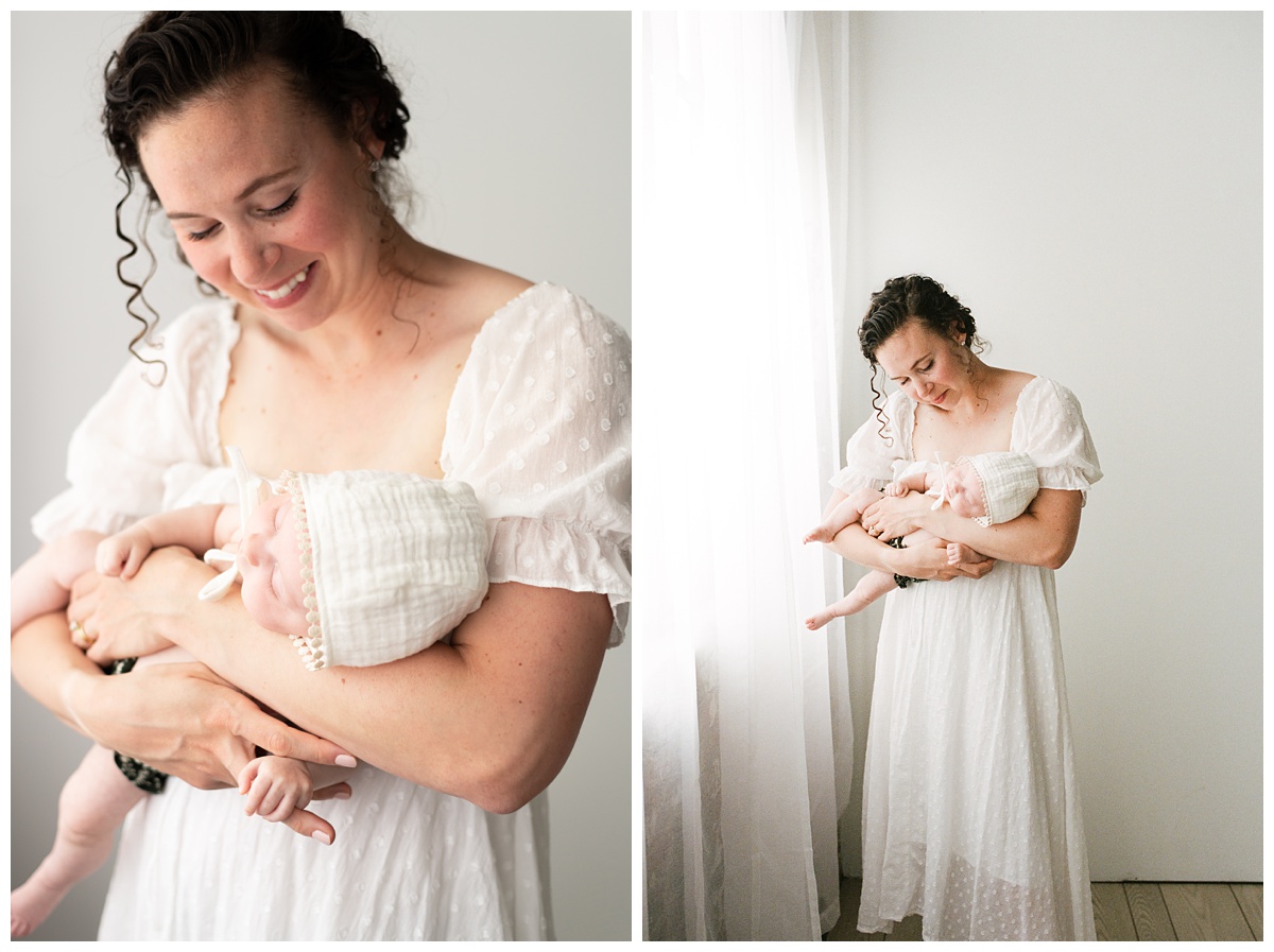 Best Columbus Ohio Baby Photographer mom holds baby girl facing out in white studio 