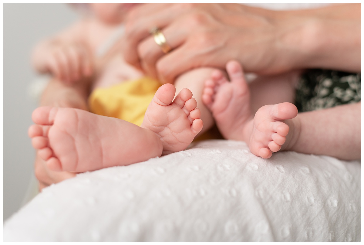 Professional Baby Photographer Columbus Ohio detail image of twins sets of feet in moms lap