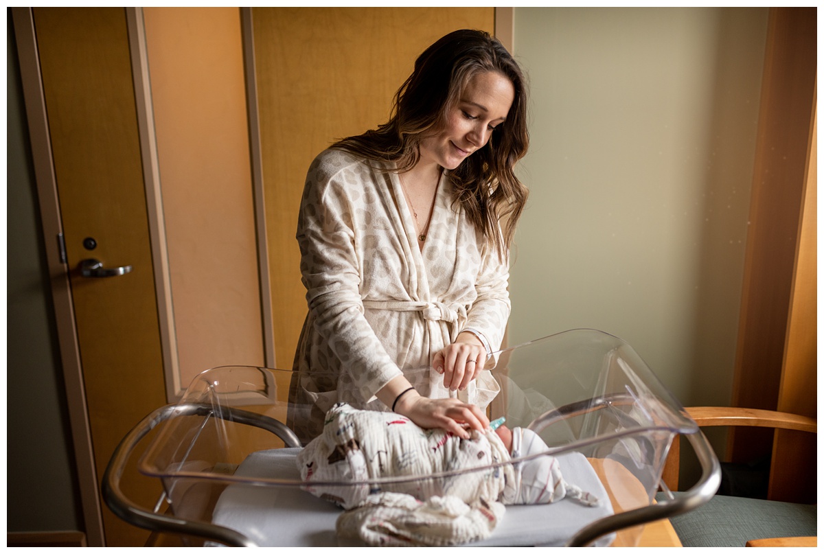 Columbus Birth Photographer new mother in leopard print robe rests hand on newborn