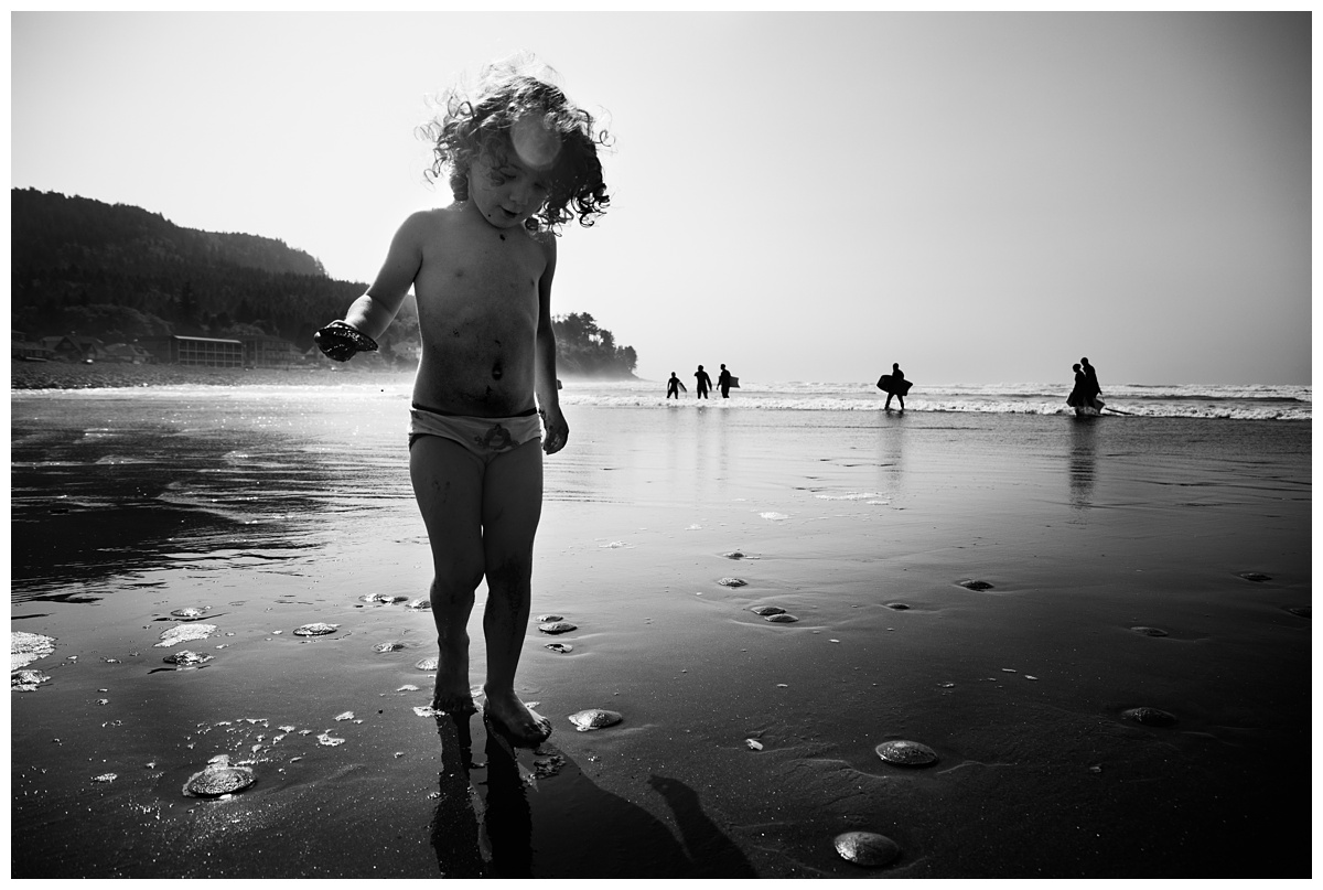 Columbus Lifestyle Travel Photographer little girl collects shells on beach in black and white