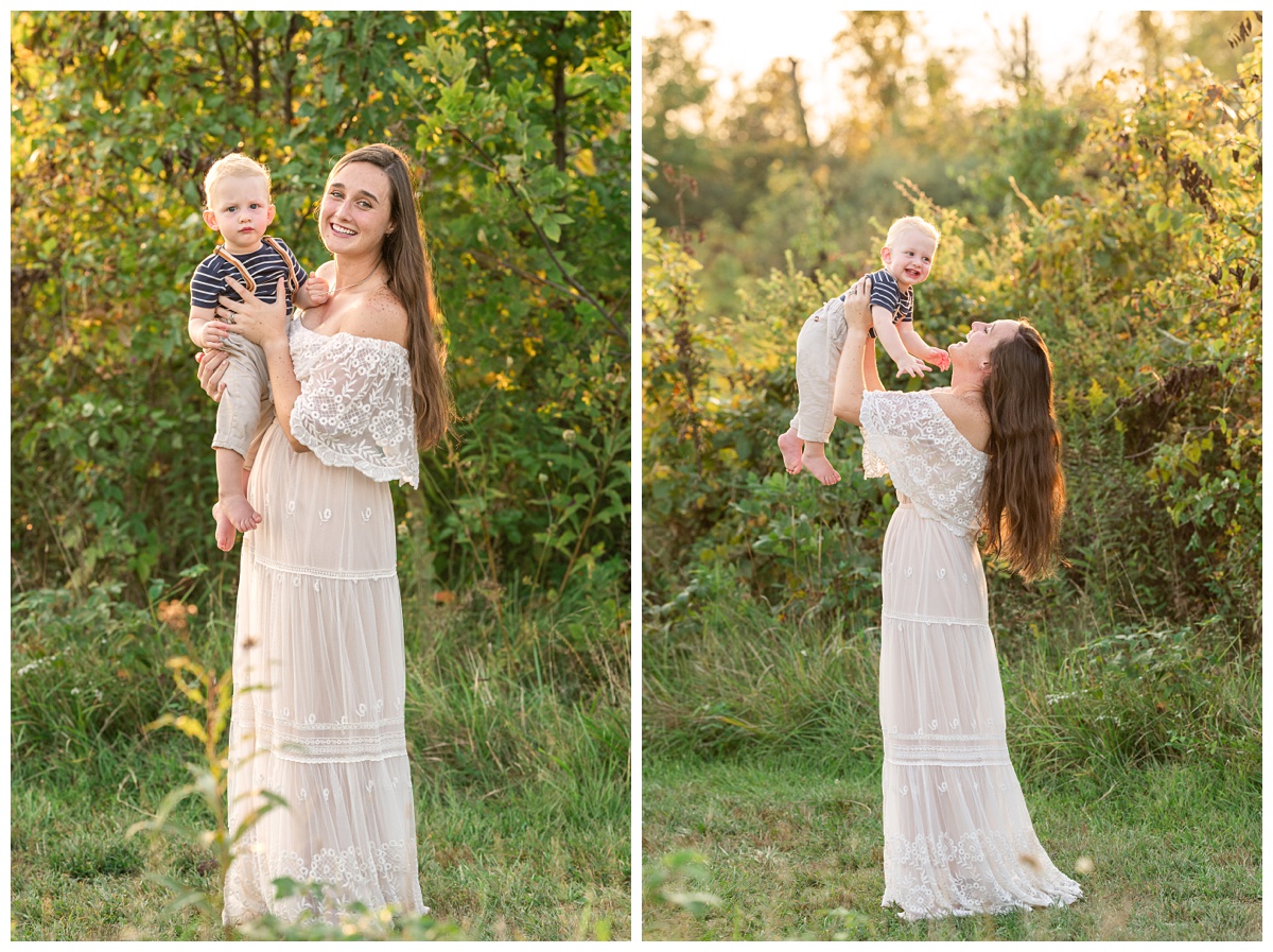 mom holds baby boy in suspenders in field at sunset