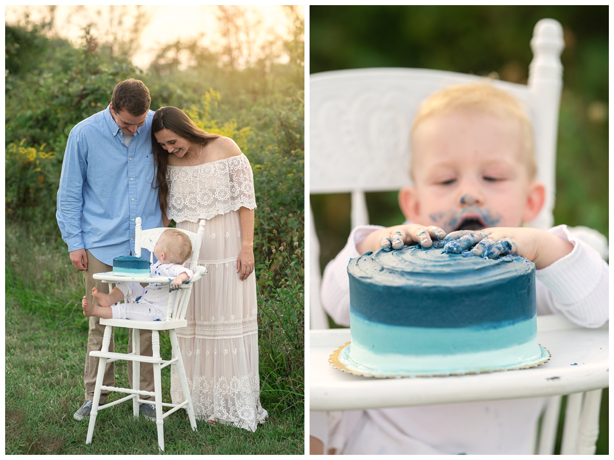 Summer Field Cake Smash baby boy grabs his blue cake with parents nearby