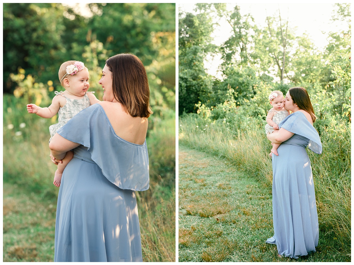 baby boy newborn Summer field milestone session mom holds daughter with blue dress in green field