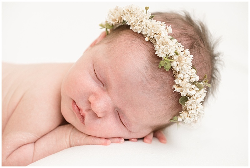 newborn girl in flower crown sleeps